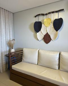 a couch in a room with hats hanging on the wall at Porto das Dunas Boutique Praia Hotel in Aquiraz