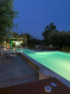 a swimming pool at night with a table and chairs at Villa Torri in Torano Nuovo