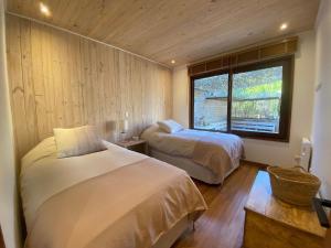um quarto com duas camas e uma janela. em Amplia casa familiar en Cachagua em Zapallar