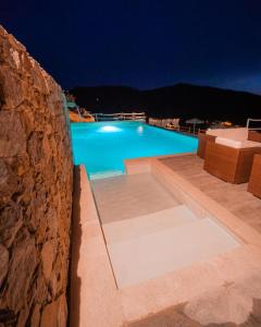a swimming pool at night with a stone wall at Angiolina's Farm in Levanto