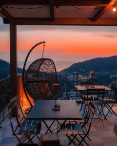 a patio with tables and chairs with a sunset in the background at Angiolina's Farm in Levanto