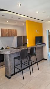 Una cocina con una gran encimera de piedra con dos sillas. en Libertador del Valle, en Rivadavia