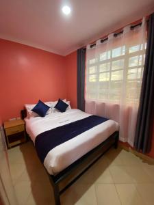 a bedroom with a large bed with a window at Todas Hotel in Kiambu