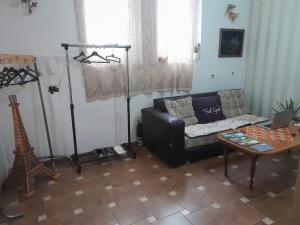 ein Wohnzimmer mit einem Sofa und einem Tisch in der Unterkunft Stay with Adem in Skopje