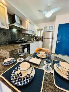a kitchen with a table with plates and wine glasses at Casas de Corintia en playa Moreno isla Margarita in Pampatar
