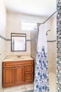een badkamer met een wastafel, een spiegel en een douche bij Relax Home Plenty Space Near The Airport - 4min in Aguadilla