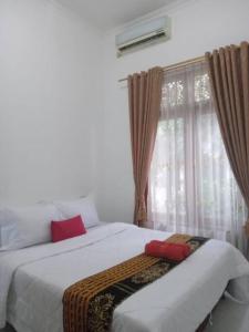 1 Schlafzimmer mit 2 Betten und einem Fenster in der Unterkunft Pringgondani Homestay in Bantul