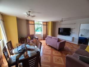 een woonkamer met een bank, een tafel en stoelen bij SUMAQ PUNUY HOSTEL - Lima Airport in Lima