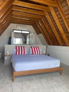 una camera da letto con un letto con cuscini rossi e bianchi di Las casitas del norte a Zorritos
