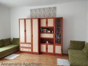 a living room with a book shelf and a couch at Bányai Apartman in Gyula