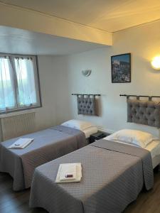 ein Hotelzimmer mit 2 Betten in einem Zimmer in der Unterkunft Hôtel Restaurant Douce France in Saint Alban Auriolles