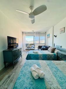 a living room with two beds and a flat screen tv at Candelaria vistas al mar in Candelaria