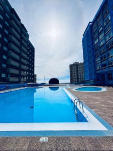 a large swimming pool in a city with buildings at Candelaria vistas al mar in Candelaria