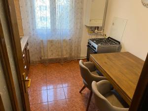 a kitchen with a stove and a table with chairs at Apartament lux 3 camere in Roman