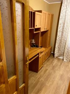 a kitchen with wooden cabinets and a wooden door at Apartament lux 3 camere in Roman