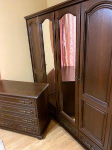 a wooden cabinet with a dresser next to a mirror at Apartament lux 3 camere in Roman