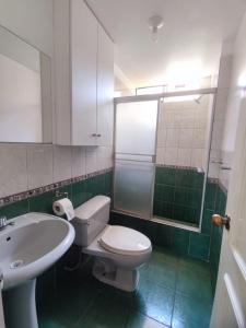 uma casa de banho com um WC branco e um lavatório. em SUMAQ PUÑUY HOSTEL - LIMA AIRPORT em Lima