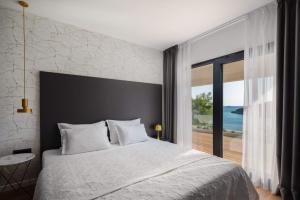 a bedroom with a large bed with a view of the ocean at Beautifully landscaped property in Selca