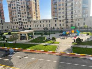 un parque infantil en una ciudad con edificios altos en Levent beach Luxury apartment, en Sumqayit