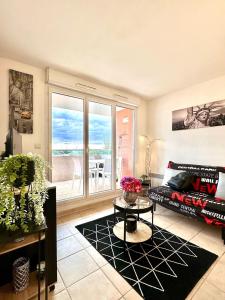 a living room with a couch and a table at L'Écrin Zen, Privé-Parking-CLIM-WIFI-4 pers in Istres