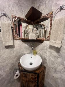 ein Badezimmer mit einem Waschbecken, einem Spiegel und Handtüchern in der Unterkunft Zury House in Quepos