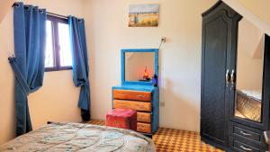 a bedroom with a dresser and a mirror at Maison de la Lagune in Oualidia