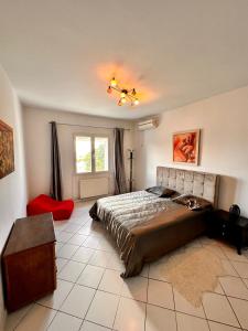 1 dormitorio con 1 cama grande y 1 silla roja en Duplex, en La Marsa