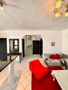 salon z czerwoną kanapą i czerwonym dywanem w obiekcie Duplex w mieście La Marsa