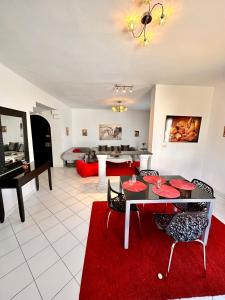 a living room with a table and a red rug at Duplex in La Marsa
