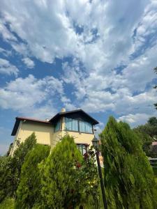 ein Haus auf einem Hügel mit wolkigem Himmel in der Unterkunft Villa Kartalkaya in Kındıra