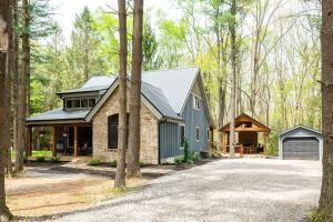 a house with a garage in the woods at West Oak - hot tub, boat slip, outdoor fireplace in Oakland