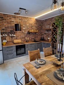 a kitchen with a wooden table and a brick wall at Kuca za odmor Sweet Dreams in Bisko