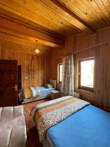 a bedroom with two beds in a wooden cabin at Villa Kartalkaya in Kındıra