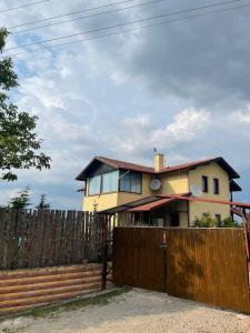 a house behind a fence with a wooden gate at Villa Kartalkaya in Kındıra