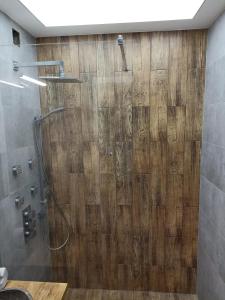 a bathroom with a shower with a wooden wall at Apartament Gdynia Panorama 2 in Gdynia