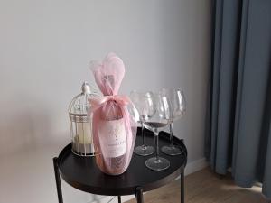 馬爾堡的住宿－SEA Apartment，一张带酒杯的黑桌和一瓶香槟