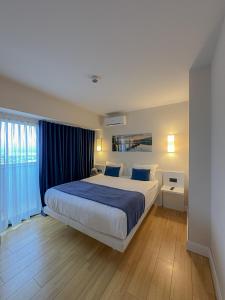 a bedroom with a large bed with blue sheets at Luxury Batumi Hotel in Batumi