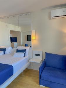 a bedroom with a large bed and a blue couch at Luxury Batumi Hotel in Batumi