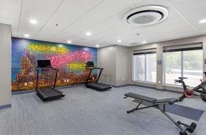 a gym with bikes and a wall with a mural at Nash Haus Hotel in Nashville