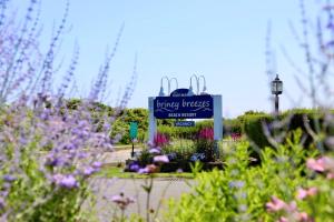a sign in the middle of a garden with flowers at Hartman's Briney Breezes Beach Resort in Montauk