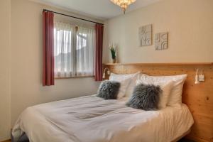 a bedroom with a bed with two pillows on it at Penthouse With Sunny Balcony And Sauna in Champéry