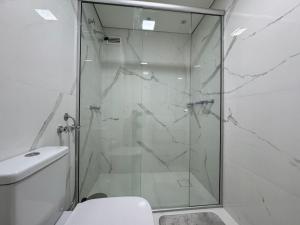 y baño con ducha de cristal y aseo. en Summit Flat Exclusivo Proximo ao center Vale shopping en São José dos Campos