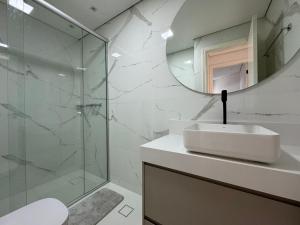 bagno con lavandino e specchio di Summit Flat Exclusivo Proximo ao center Vale shopping a São José dos Campos