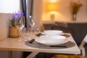 a table with plates and wine glasses on it at VRBNIK OLD CITY LOFT in Vrbnik
