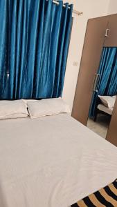 a bed in a room with a blue curtain at Royal Square Service Apartment in Thrissur Town in Trichūr
