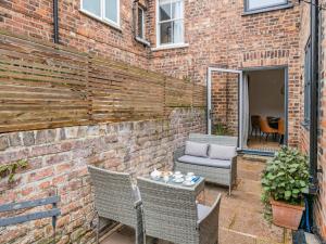 een patio met een bakstenen muur en stoelen en een tafel bij 2 Bed in York 94487 in York