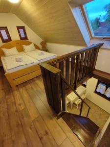 a attic room with a bed and a staircase at Szent Iván Vendégház in Tata