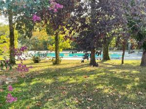 un parque con árboles y flores y un cuerpo de agua en Au Cœur des Acacias, en Lauzun