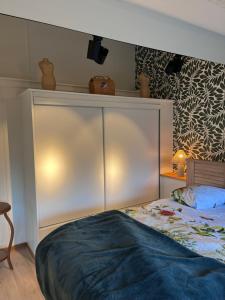 een slaapkamer met een bed en een witte kast bij Cottage Apolline in Santenay