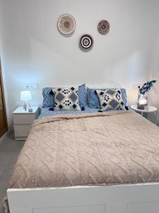 1 dormitorio con 1 cama grande con almohadas azules en Estudio coqueto con Terraza, en Alicante
